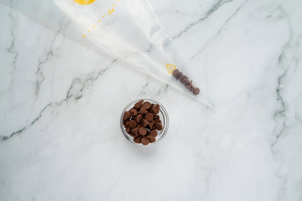 adding chocolate chips to piping bag for back to school smores treat bags