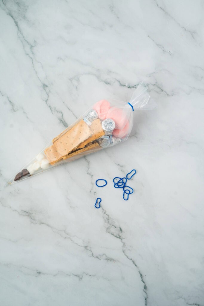 using a rubber band to close the pencil themed back to school goodie bags