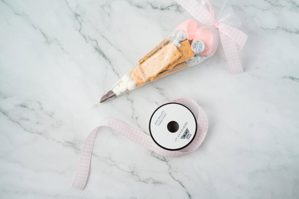 completing the back to school smores treat bags with a pink gingham ribbon